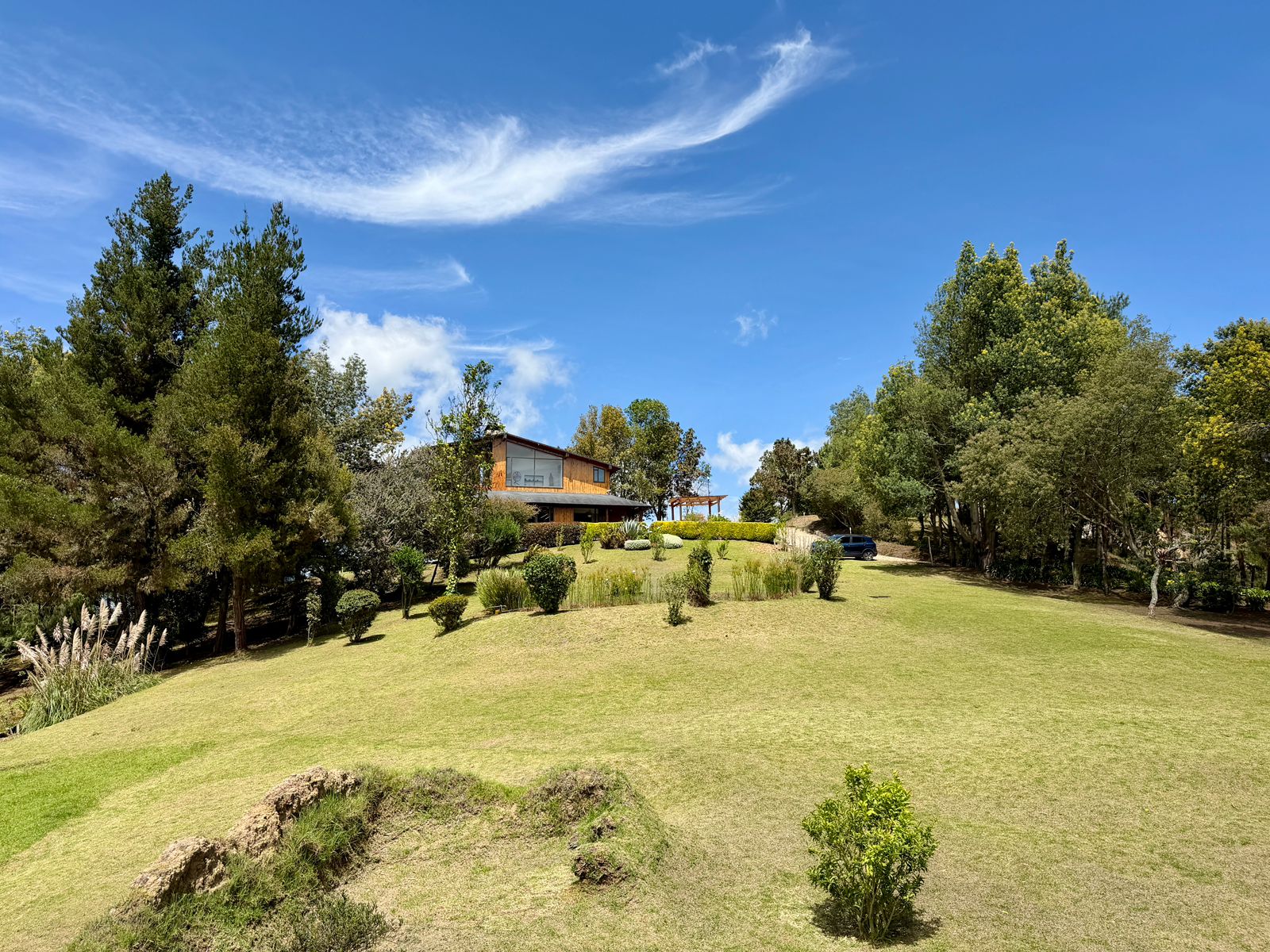 Amplios jardines y vista exterior de El Encanto bajo el cielo azul de Guasca